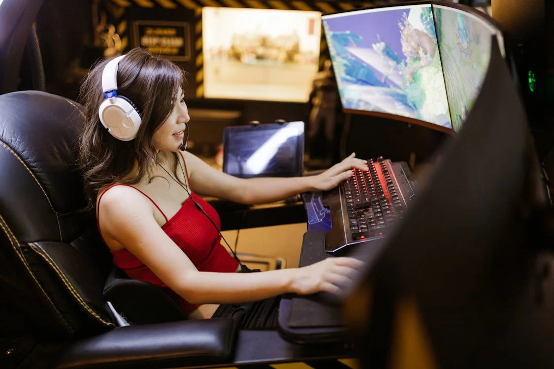 girl wearing white headset gaming on a pc with 3 monitors